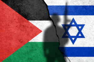 Flags of Israel and Palestine painted on the concrete wall with soldier shadow. Gaza and Israel conflict